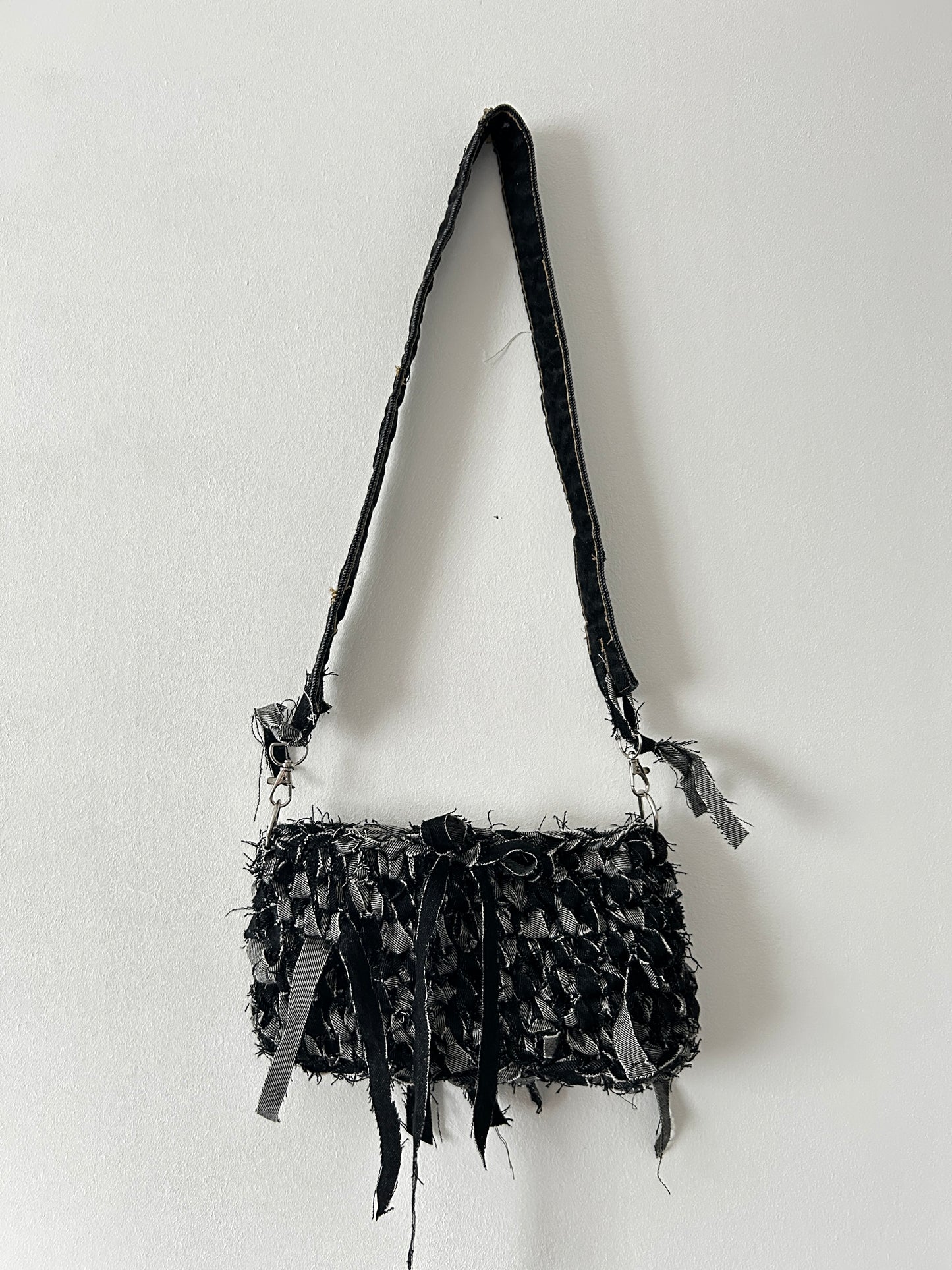 dark denim crochet shoulder bag with a distressed look