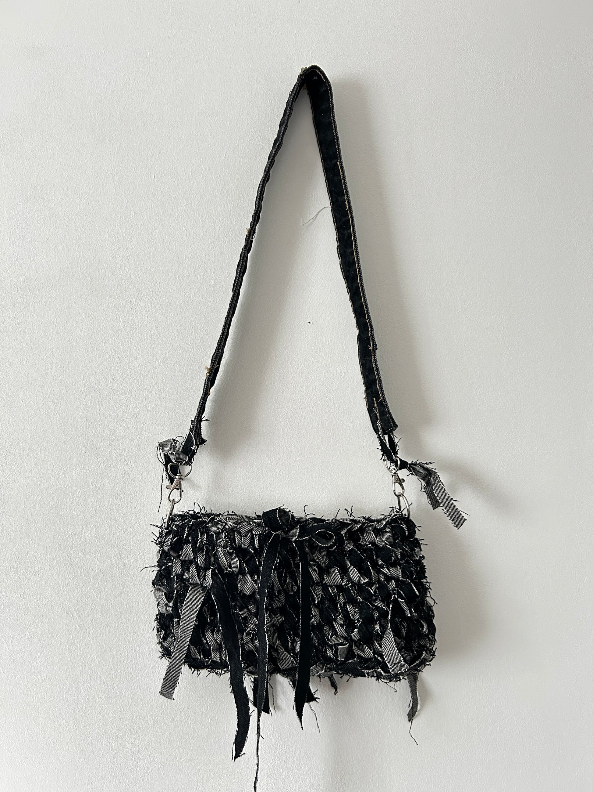 dark denim crochet shoulder bag with a distressed look