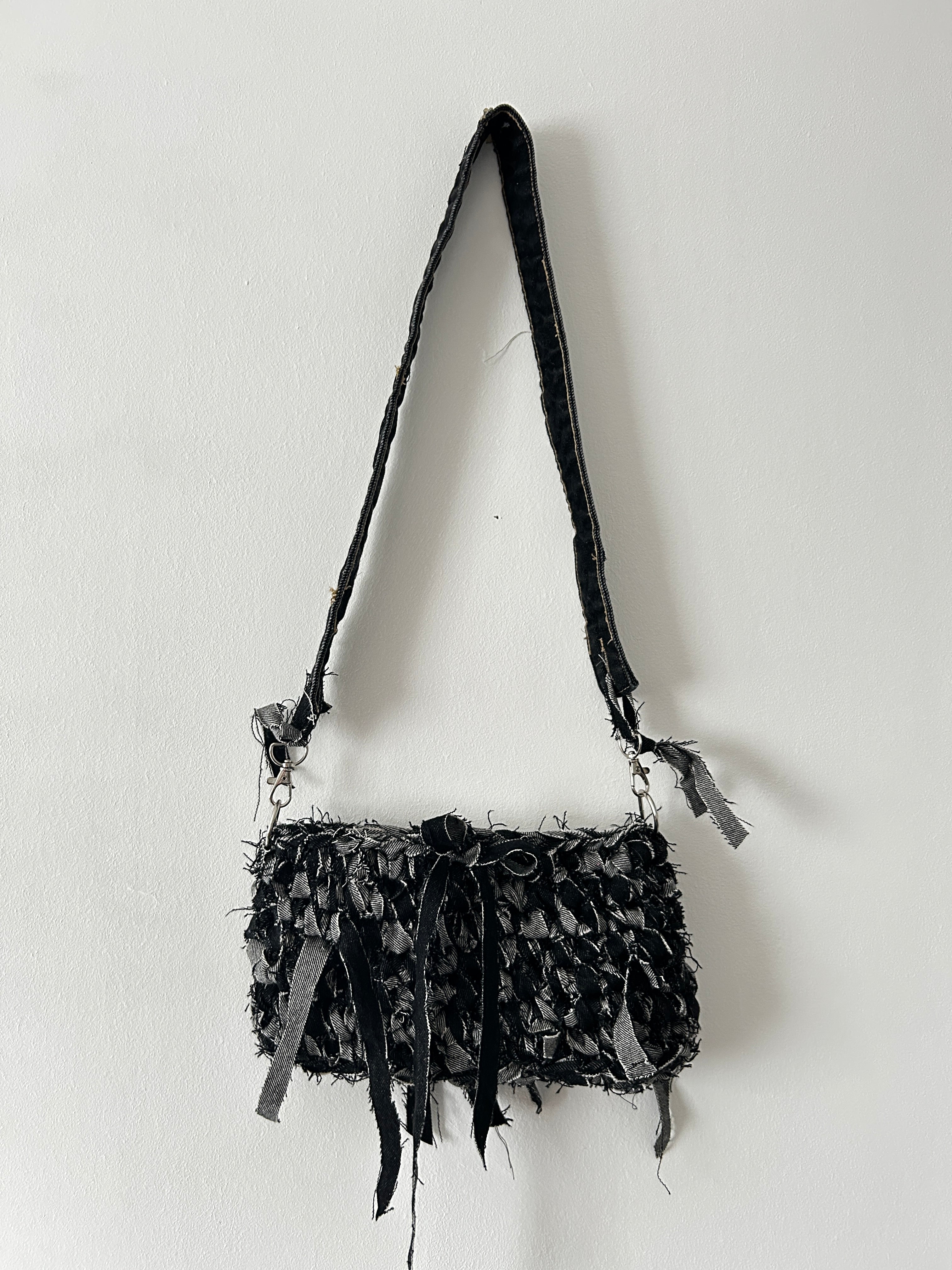dark denim crochet shoulder bag with a distressed look
