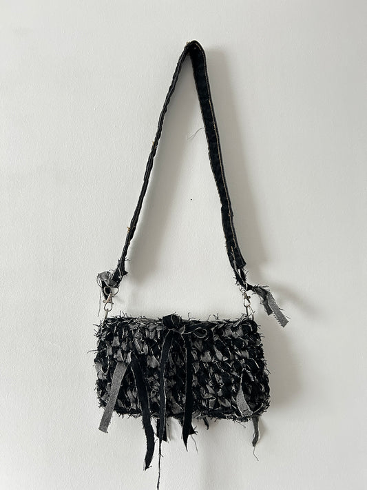 dark denim crochet shoulder bag with a distressed look